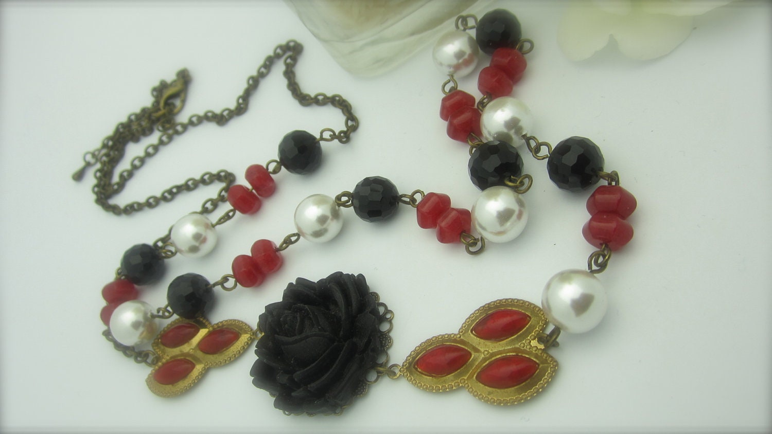 CHATTER BOX - Black Facetted Beads Paired With White Glass Pearls, Rubies Then Adorn With A Black Rose Cabochon