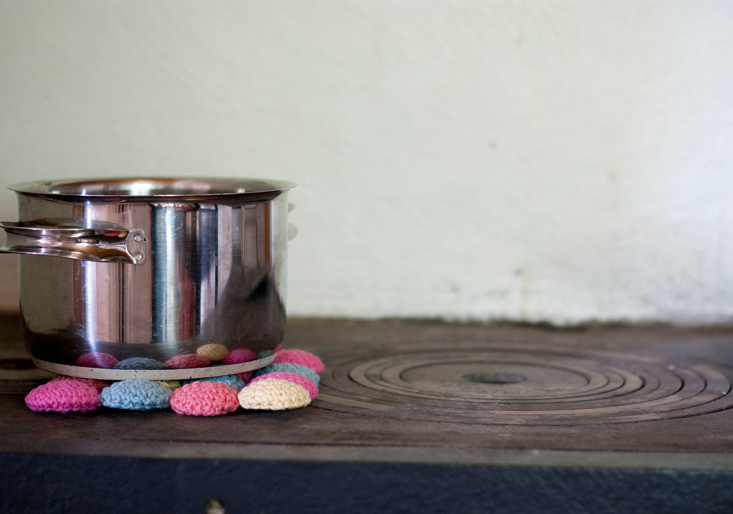 Eco cotton and wood trivet in pastels. Crocheted circles in pink, peach, yellow and blue. Eco friendly.