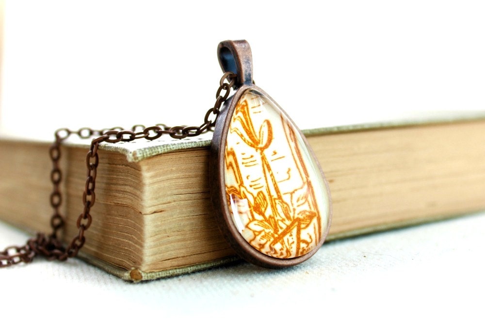 Necklace with victorian gilded age swirl flourish motif in ginger orange rust brown red from vintage sheet music under glass