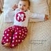 Red polka dot pajamas with initial in a heart or circle