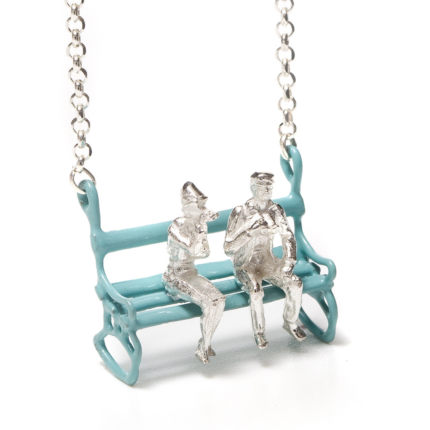 Silver necklace with a lovely couple sitting on a  pastel blue bench