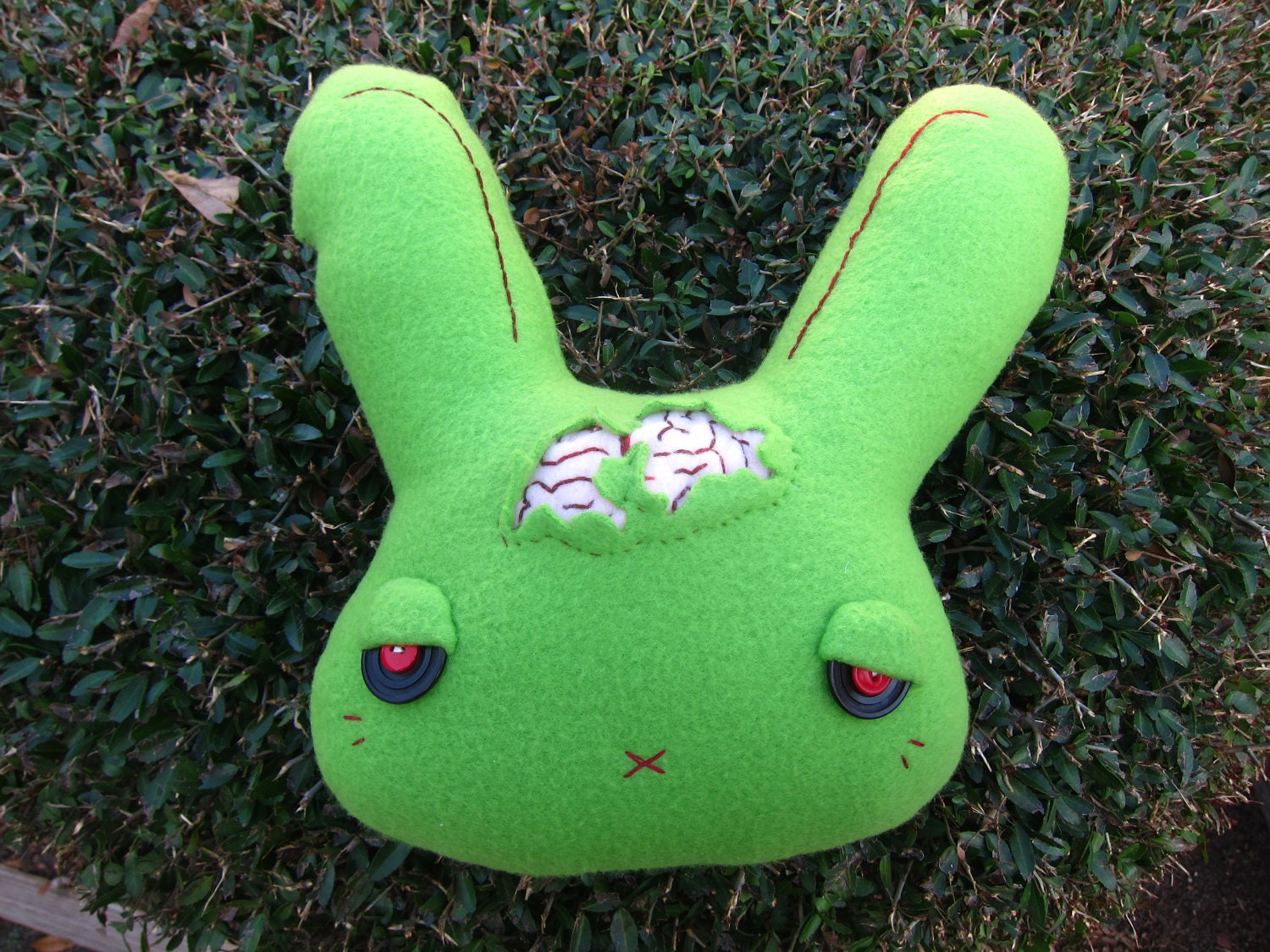 Green Zombie Bunny Head Fleece Plush with Red and Black Eyes, Brain Poking Out, and Ear Bitten