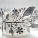 Metal foliage wrapped around a fine bone china vessel
