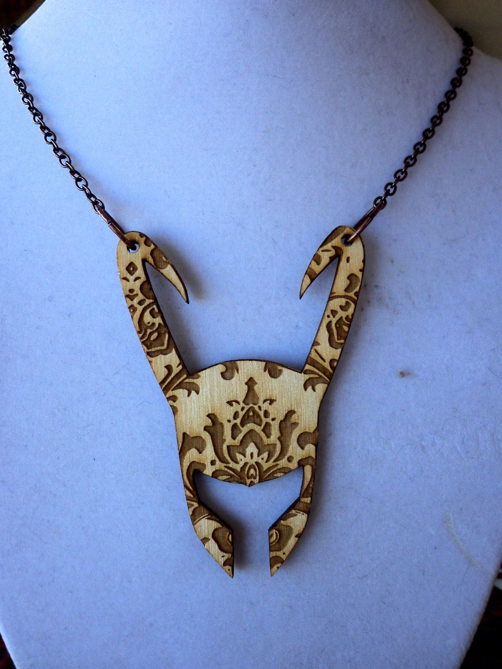 Patterned Loki helmet necklace.