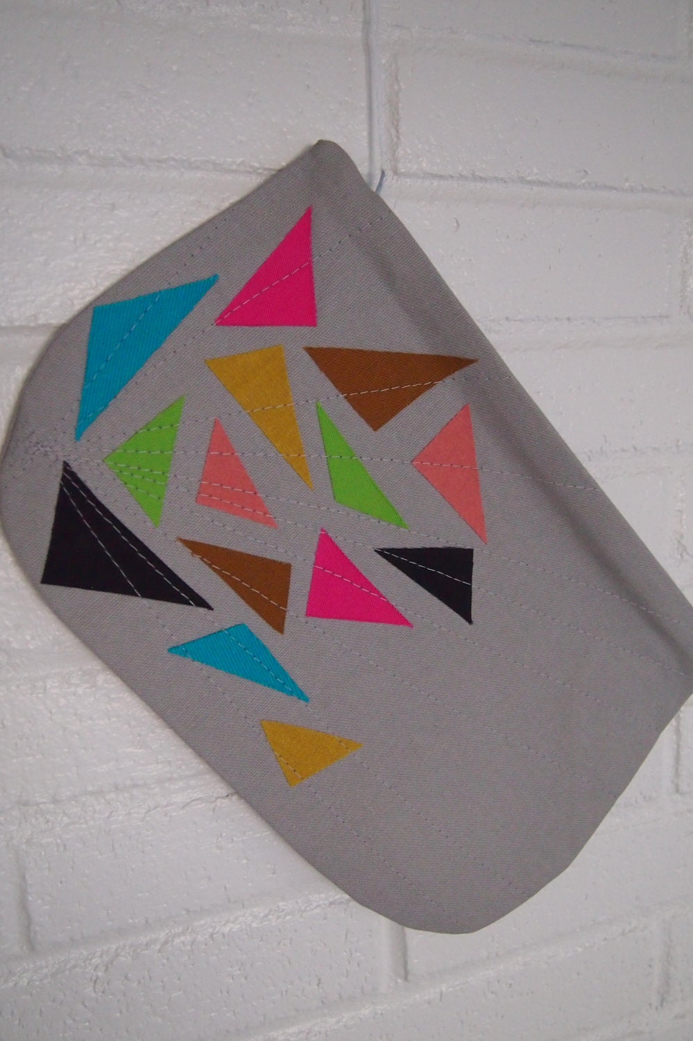 Triangle zipper clutch in grey.