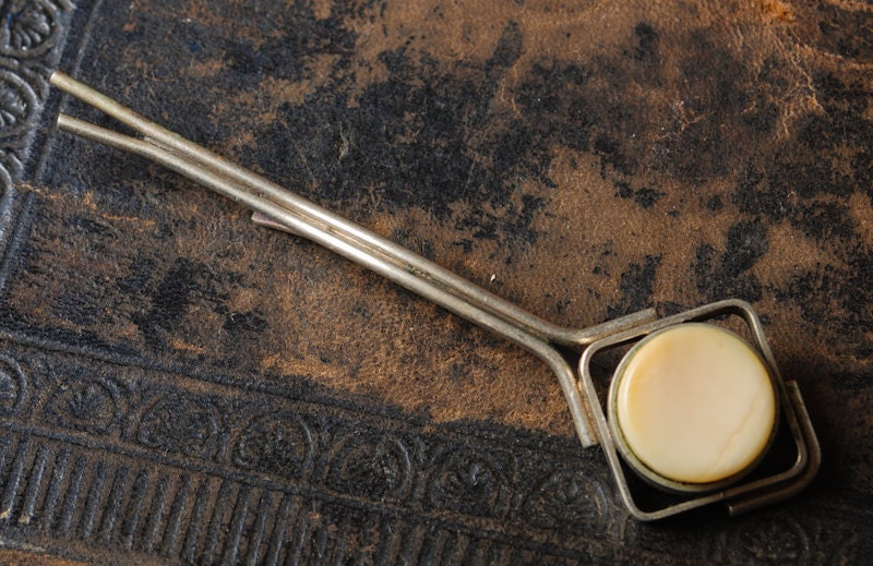 Vintage silver tone metal tie bar clip with white gemstone.
