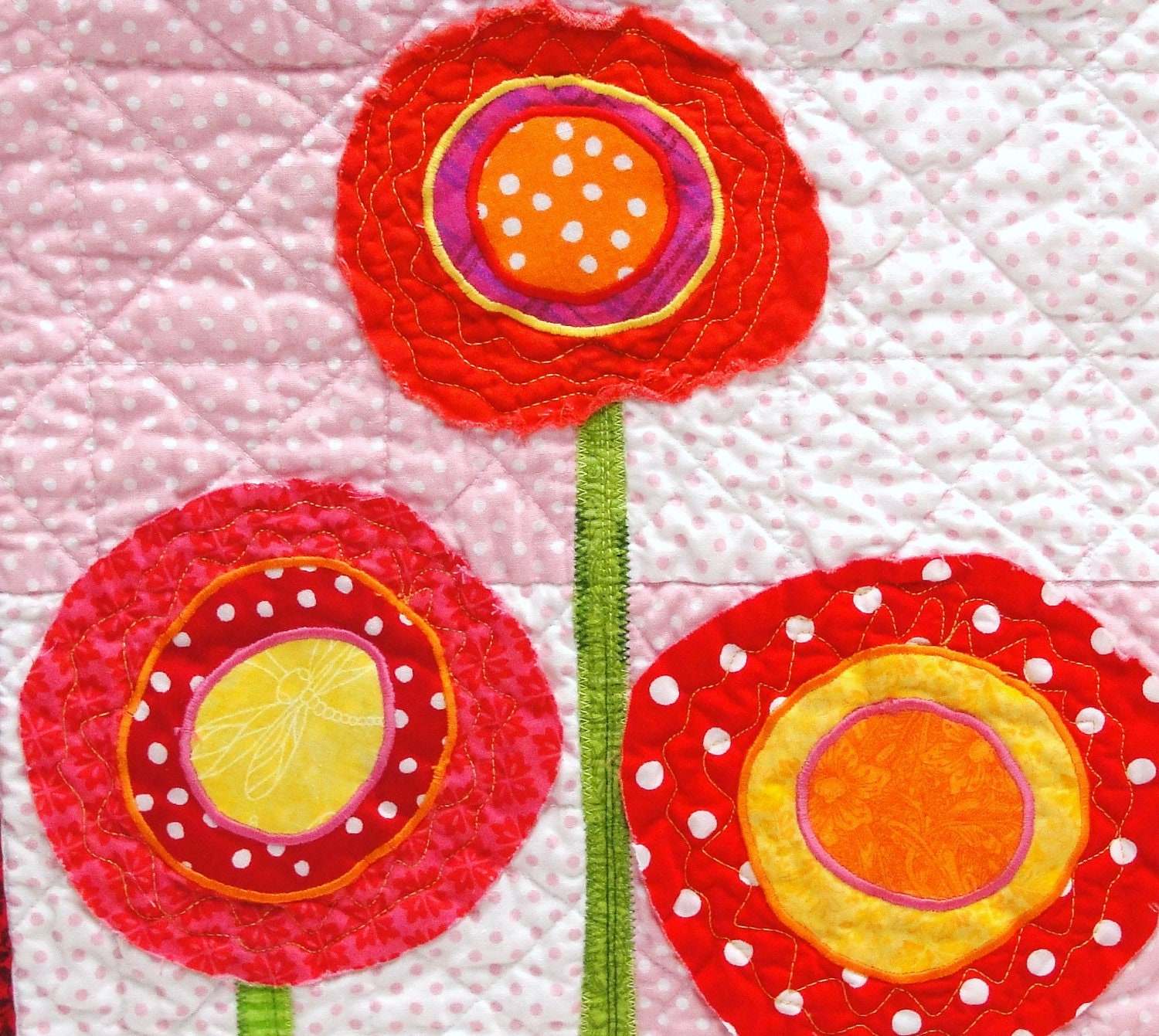 poppy quilt-  wall art quilt in pink, red, orange and yellow on pink background