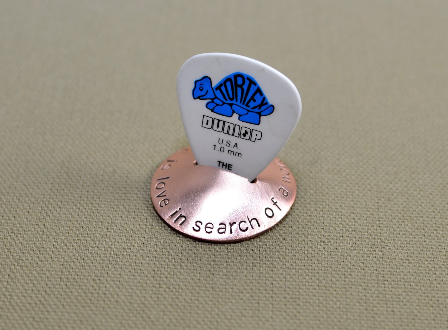 Copper guitar pick stand rocking with music is love in search of a word
