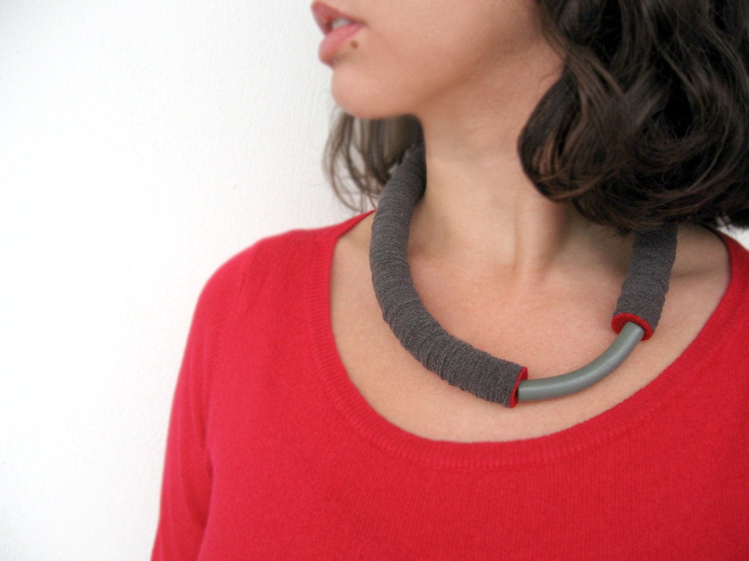grey tube minimal geometric necklace with an arc ceramic bead and a red touch