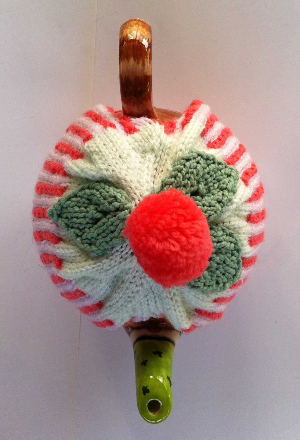 Stripy tea cozy with leaves and a pom pom