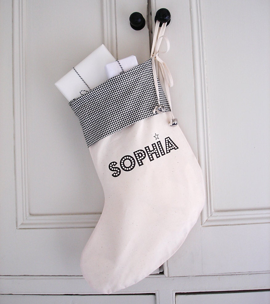 custom childrens christmas stocking : unbleached cream cotton with black printed name, tied with bow and silver jingle bells