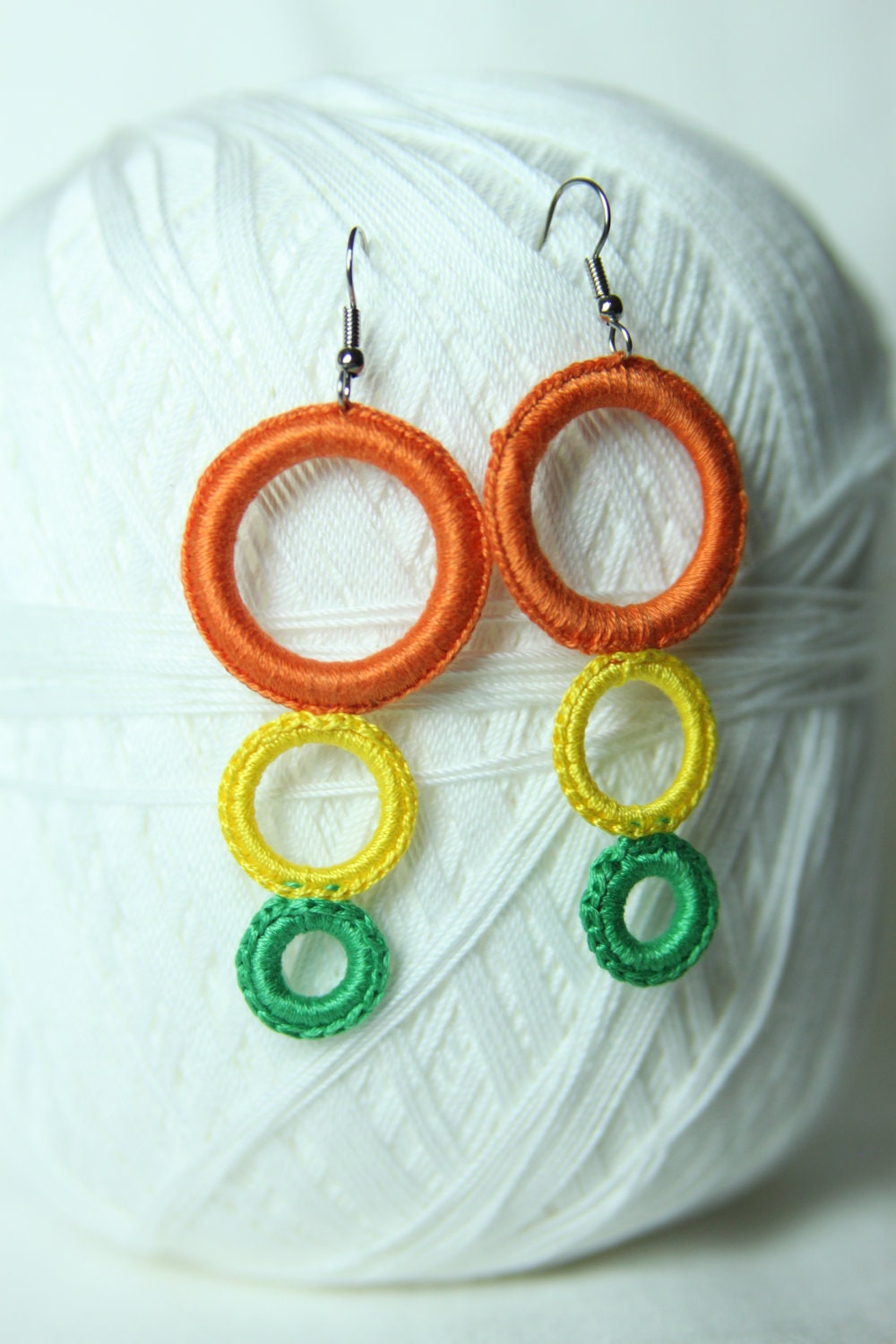 Crocheted dangle orange, yellow, green earring.
