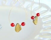 Large hoop earrings with gold czech leaves and bright red glass beads.