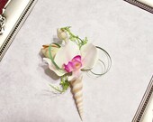 Men's Boutonniere with white orchid with a rose colored throat, buds and a shell stem.