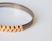 Sienna suede bangle. Dusty peach suede, herringbone pattern woven together around two bronze colored bangles. Small size.