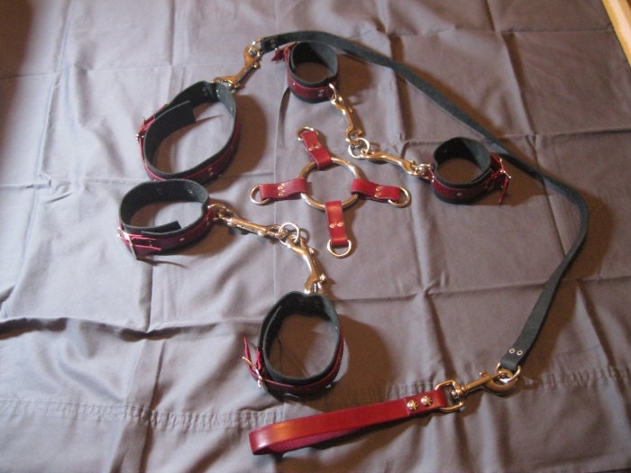 Five piece red and black leather bondage restraint set, hand cuffs, ankle cuffs, collar, lead and 4-way ring