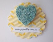 A sparkly aqua glitter brooch