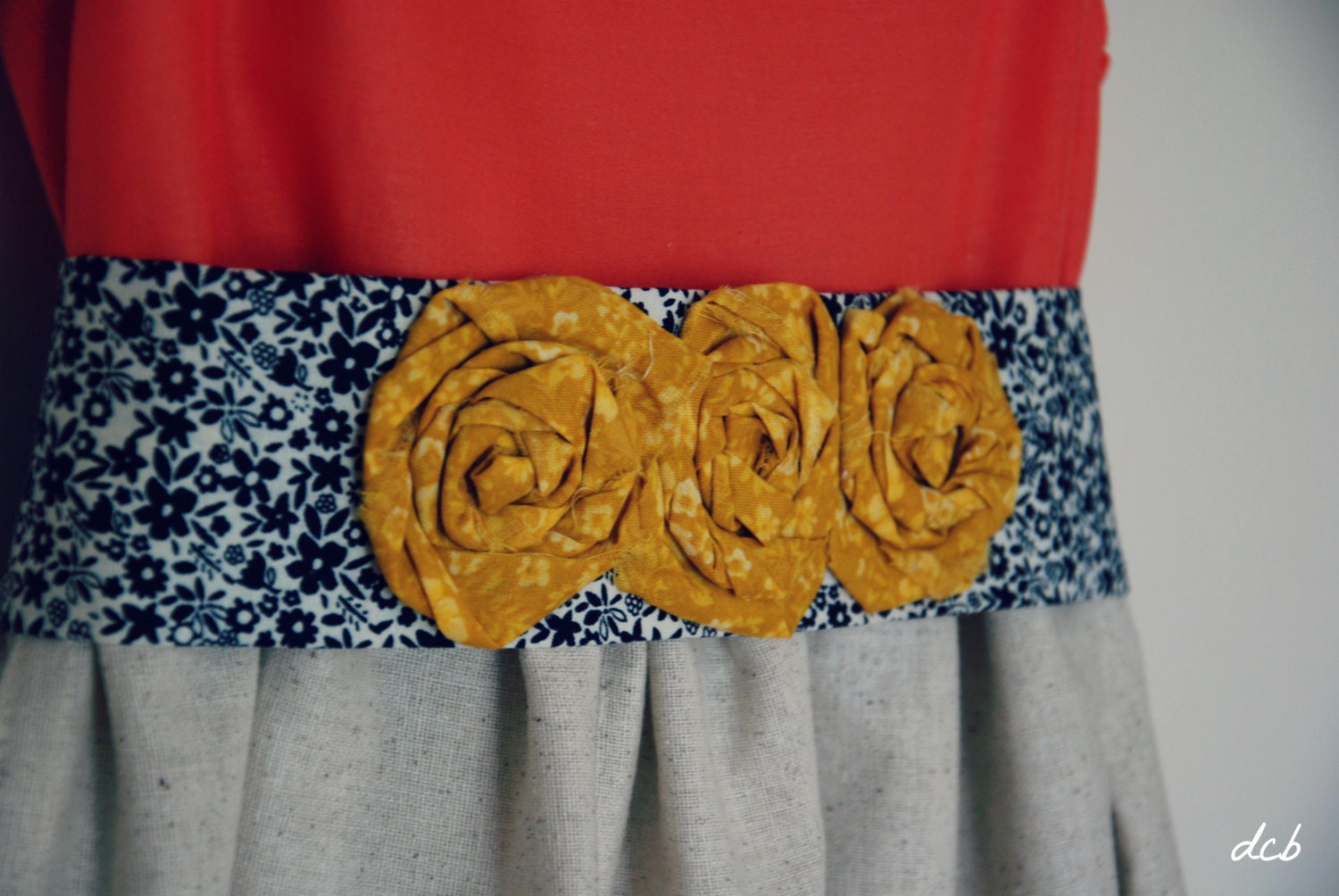 Coral cotton dress with mustard and navy sash