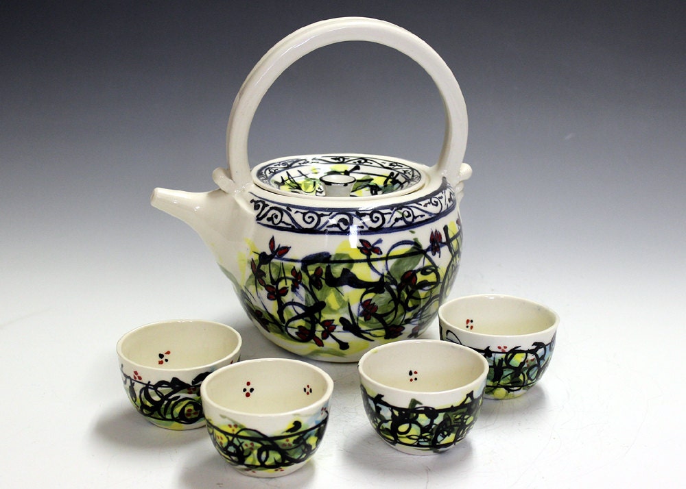 Ceramic and pottery tea set with four matching tea bowls.