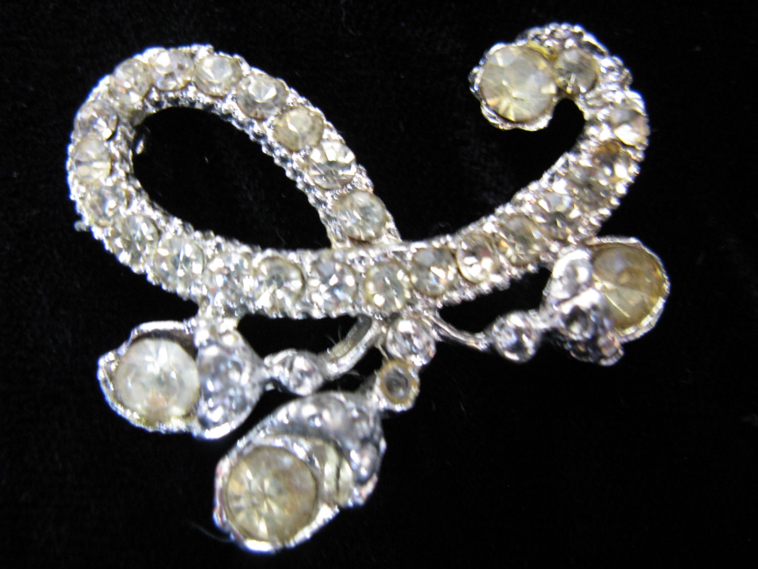 1950's silver rhinestone dress pin. jeweled swirl brooch.