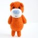 Needle felted orange pocket bear with a light blue nose