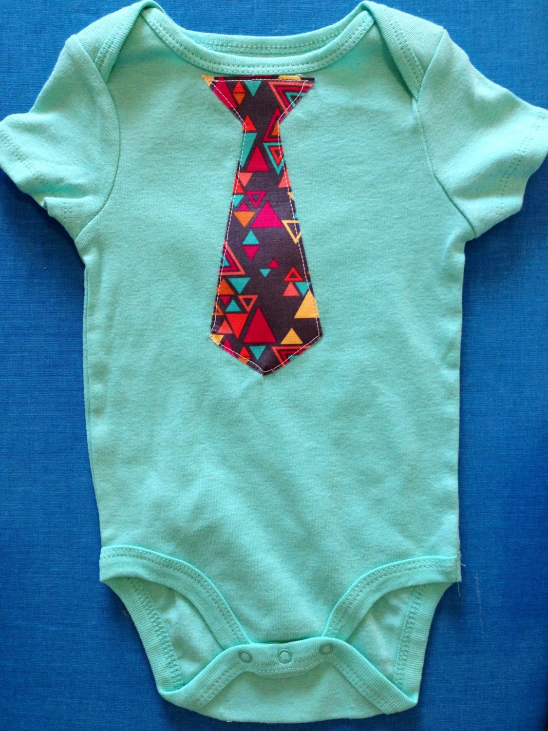 turquoise onesie with geometric tie. tie onesie. boy onesie. triangles. geometric. easter. 6-9 months.
