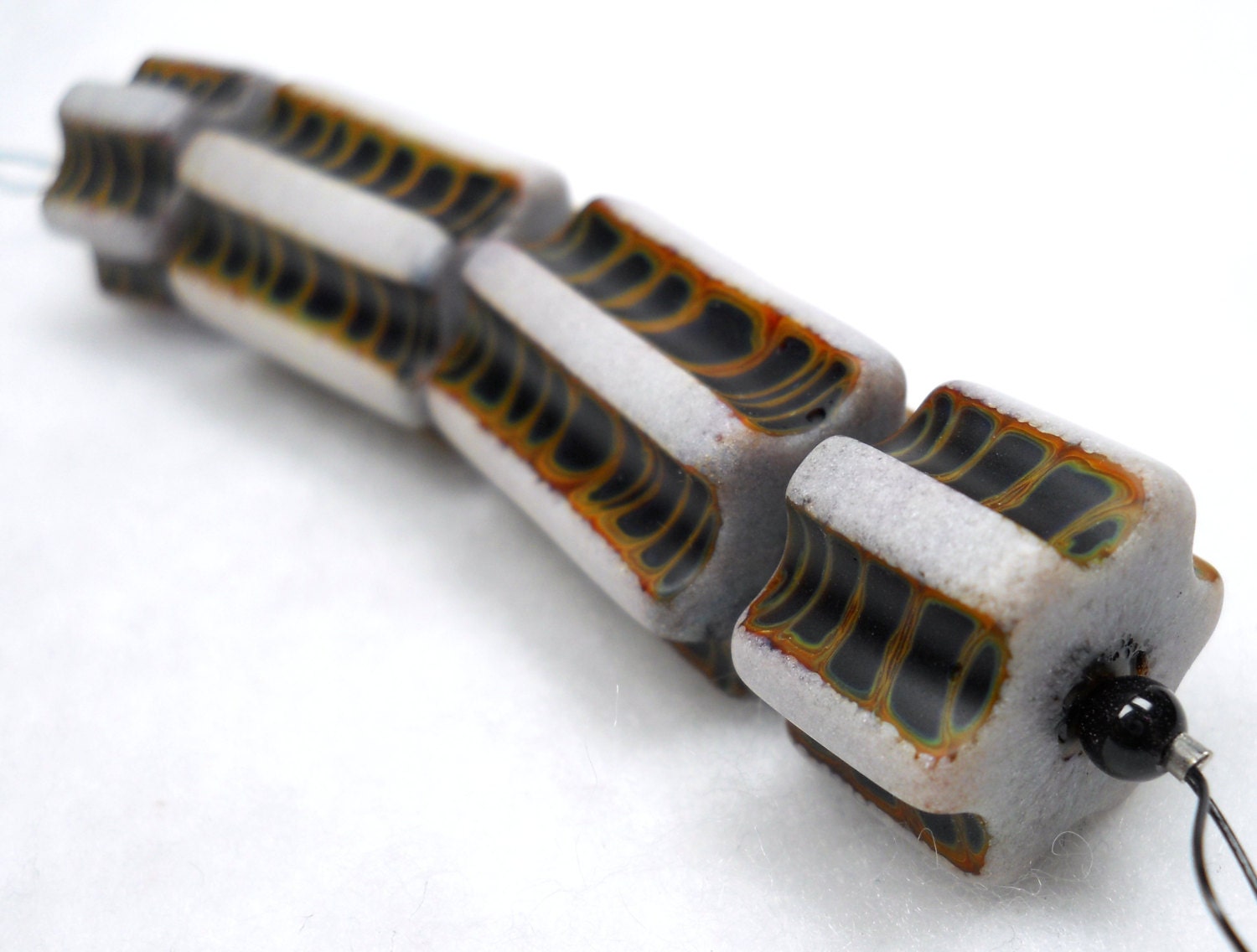 American Trade Bead - Nevada - Strand of 4 cylinder beads. Solid carved boro glass lampwork.