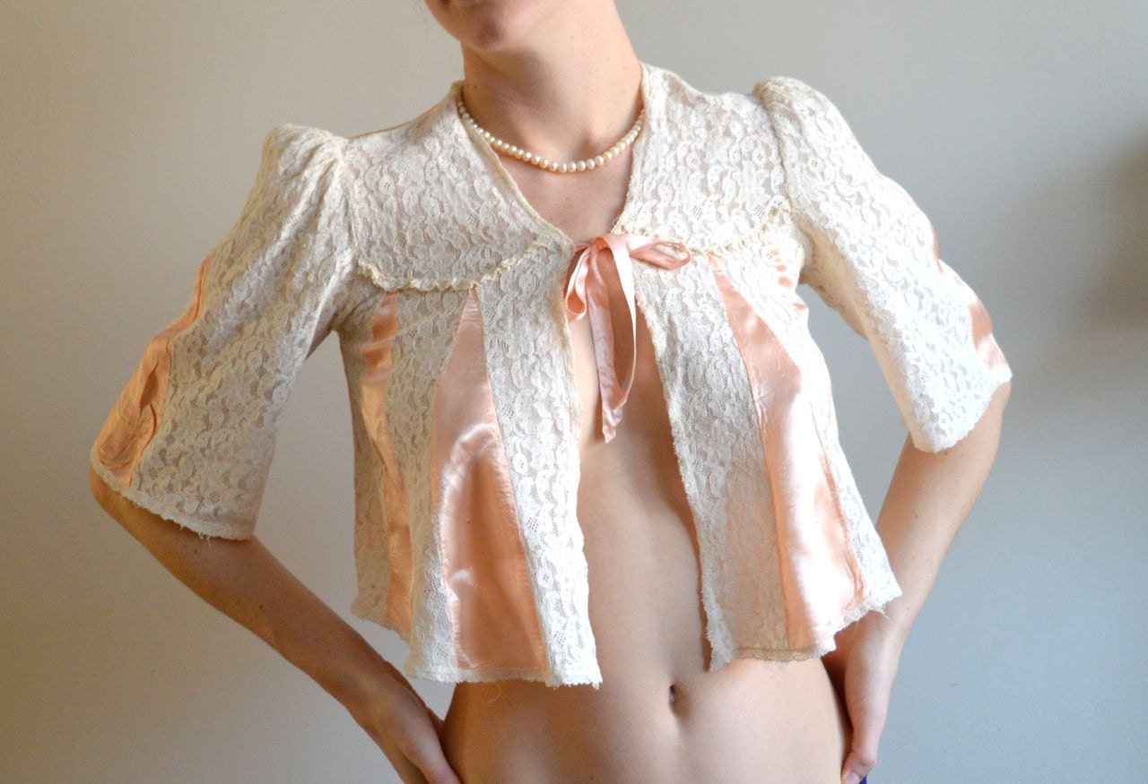 Coral bed jacket with lace & ribbon. Pale coral, lacy, sexy.