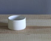 one small open white salt cellar. white gloss glazed porcelain dish. minimal modern pottery ceramic