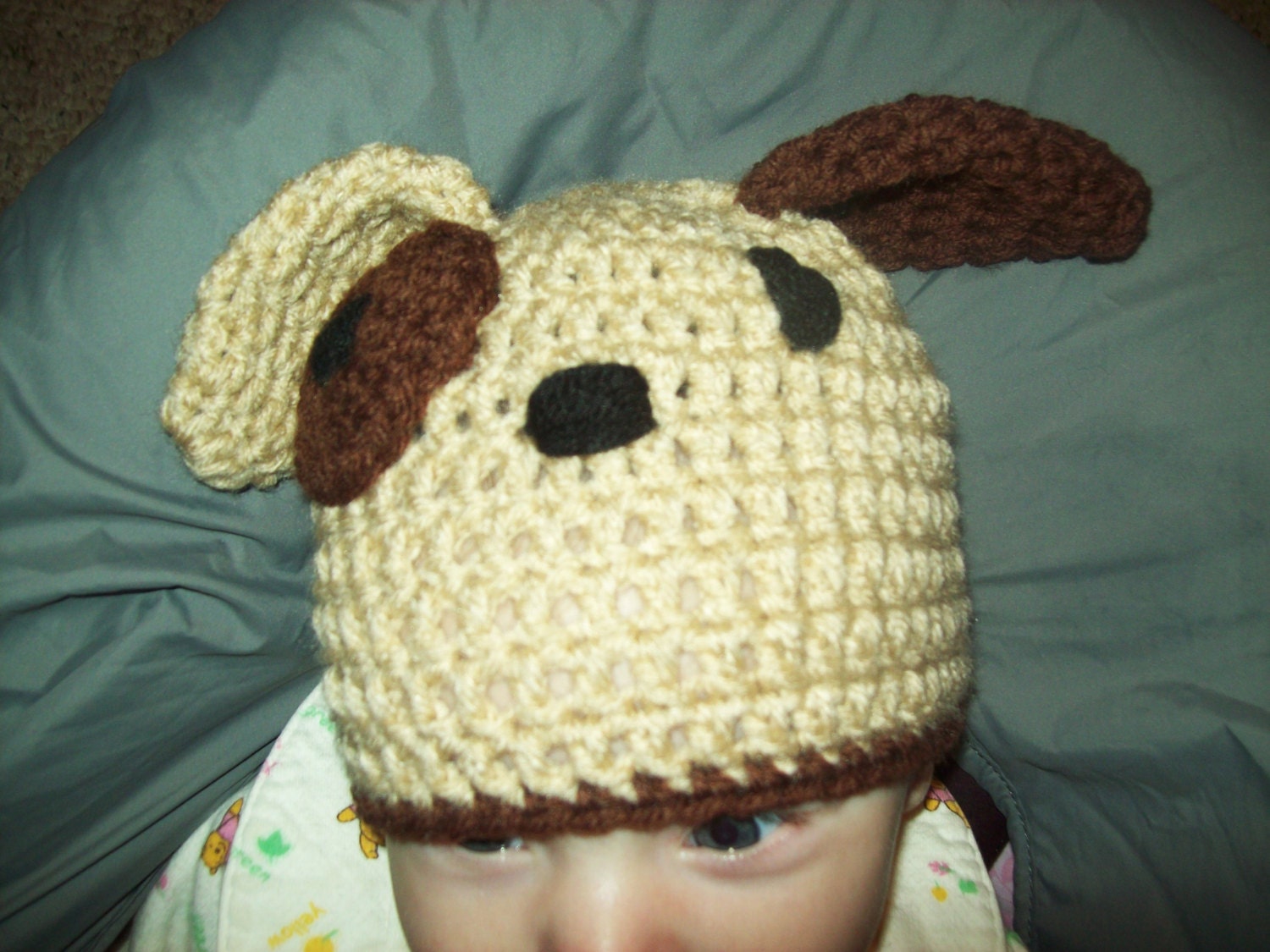 Handcrocheted Puppy Hat for 3 to 6 month babies. Tan bull dog with brown ear and eye patch. Made with Red Heart 100% acrylic yarn.