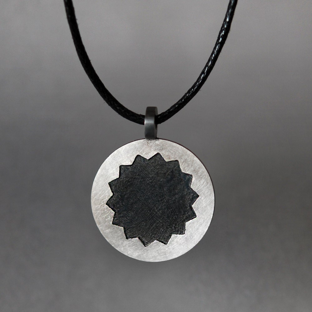 Round silver necklace. Solid round silver disc with etched geometric, black, flower like shape. Handmade.
