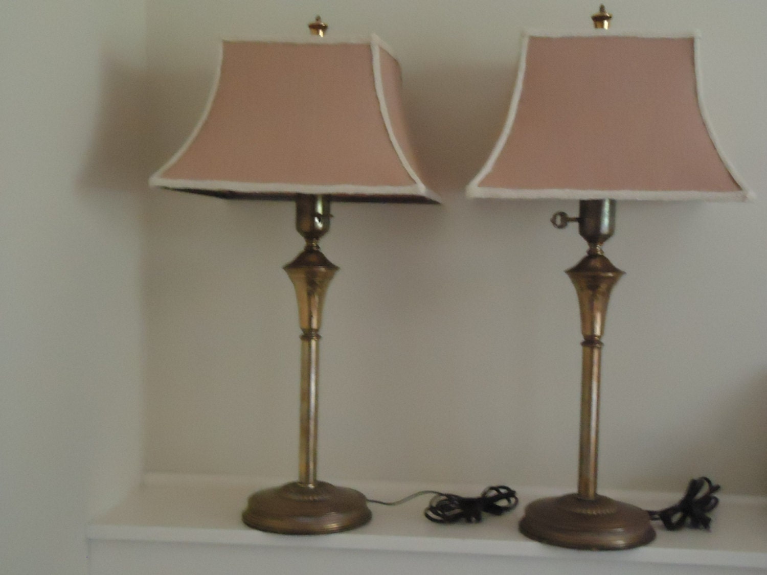 A pair of vintage brass lamps with linen shades