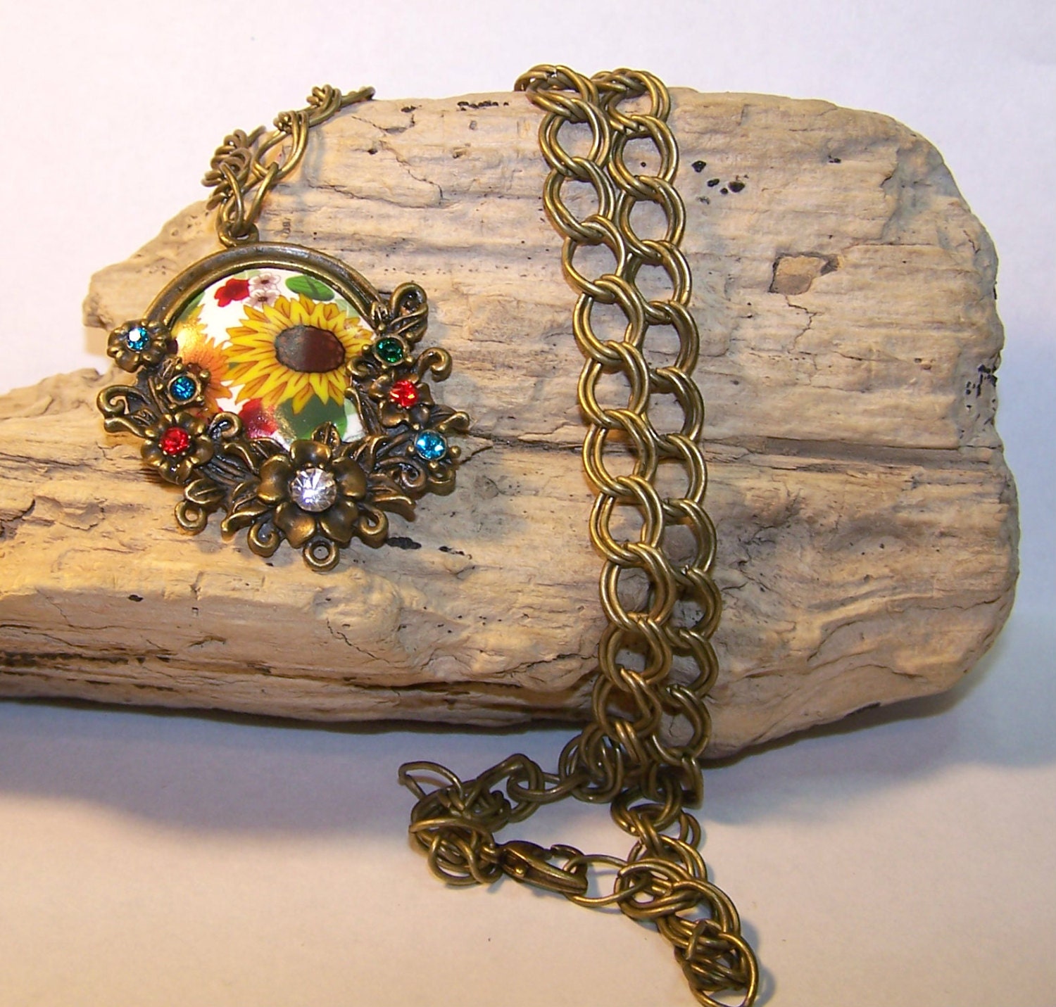 Vintage styled Antiqued brass Sunflower Garden pendant featuring handmade focal bead and crystal accents.