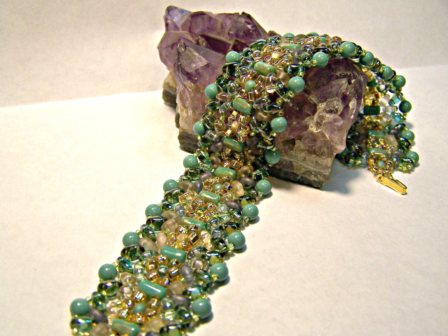 Beadwoven bracelet in greens and gold with gold clasp