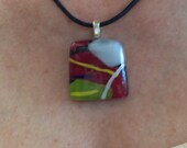 Fused glass pendant, black, dark red, olive green, white, and yellow