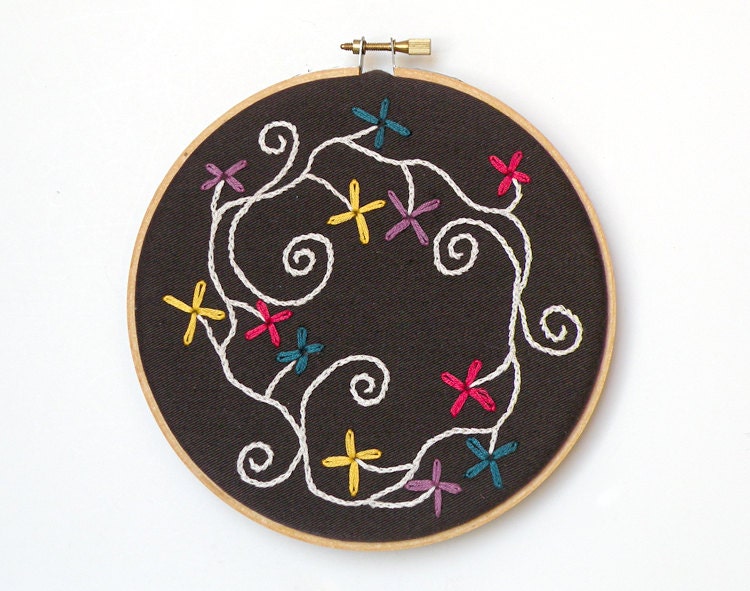 Red, purple, yellow and blue embroidered flowers in 6" round wood embroidery hoop wall art