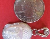 Precious hand-carved MOTHER of PEARL BUDDHA set in sterling silver and a hidden treasure on the back. a beautiful om .
