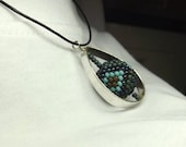 Beadwork necklace - teardrop bead frame holds a spinning bead stitched in denim and turquoise seed beads