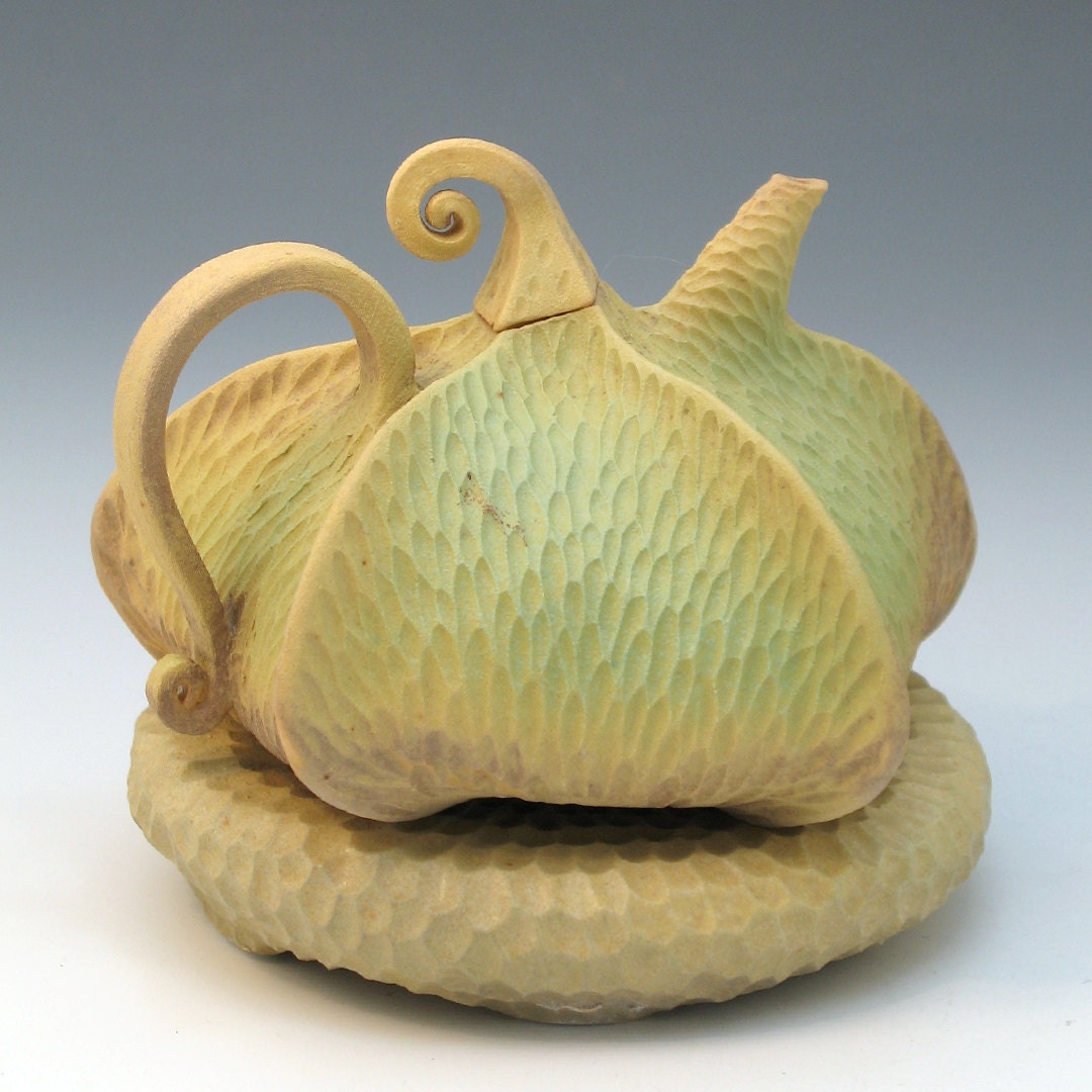 Green & brown carved porcelain teapot with tan pillow