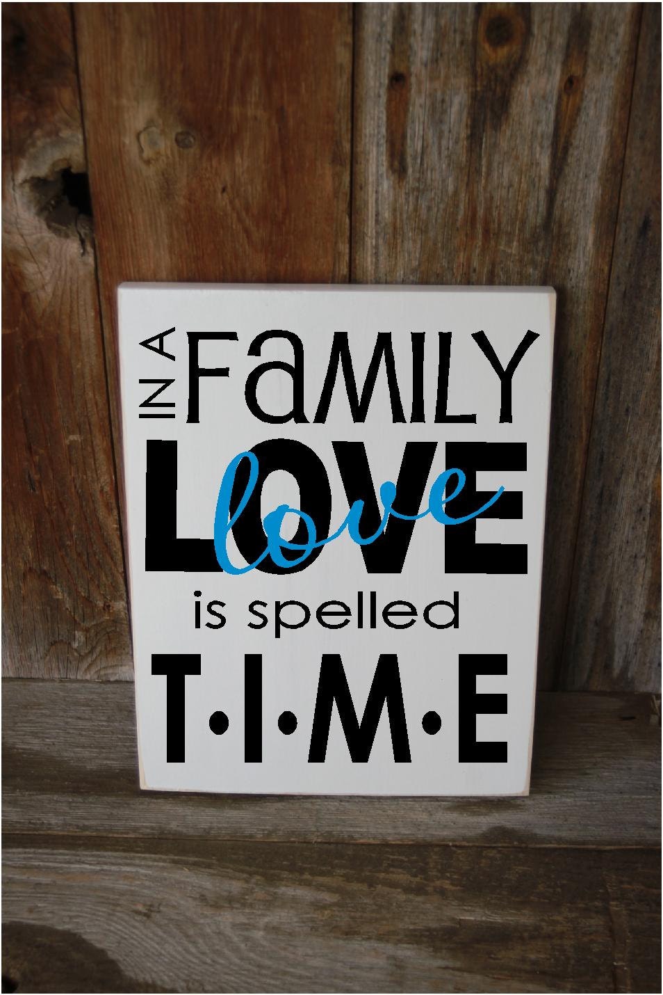 In a FAMILY LOVE is spelled TIME - cute family home wood board with vinyl lettering