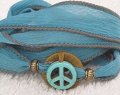 Silk Ribbon Whirly Wrap Bracelet in Teal Turquoise with a ceramic peace symbol peace child