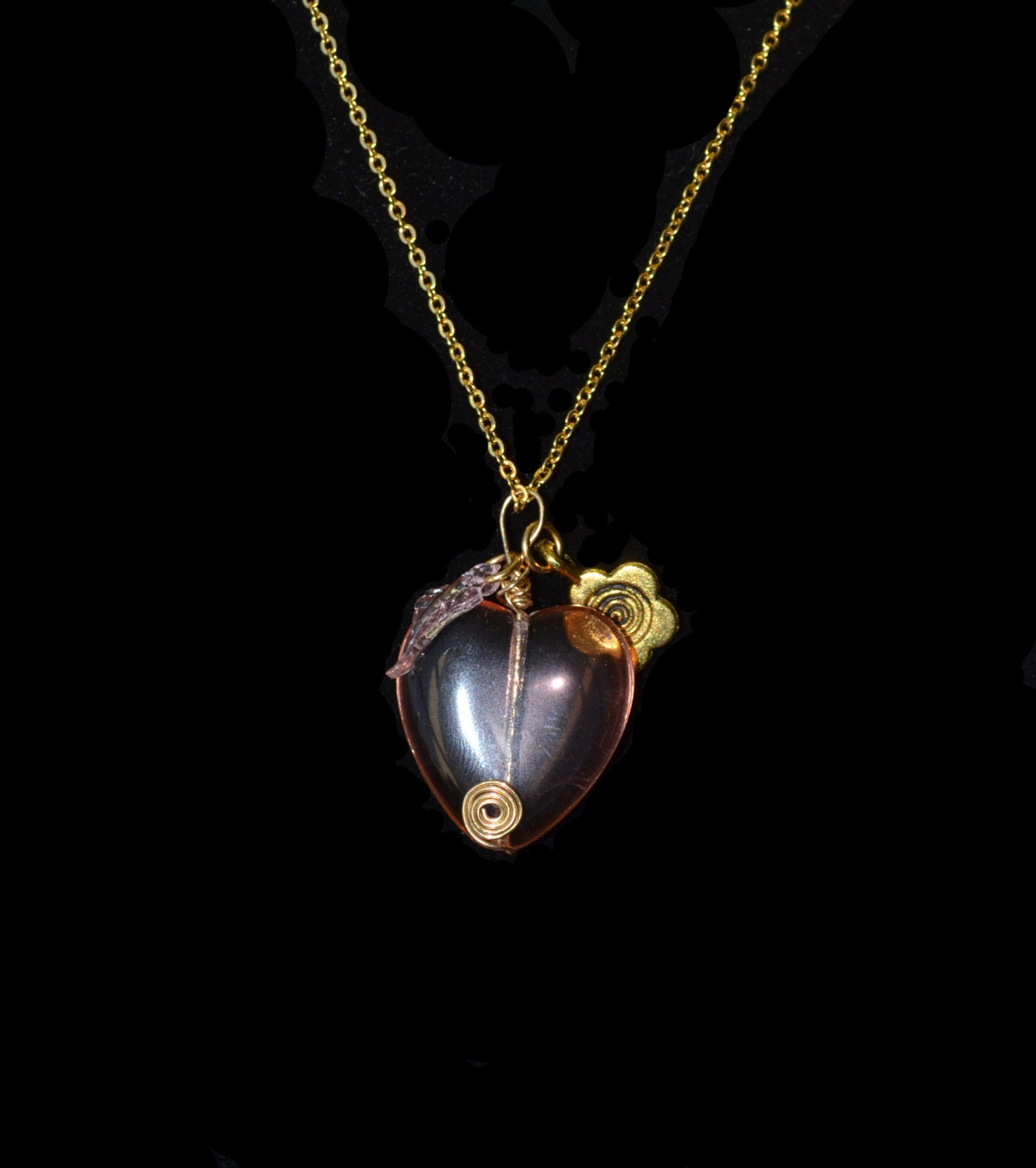 Wire-wrapped pink glass heart with leaf and a gold flower charm, chain included