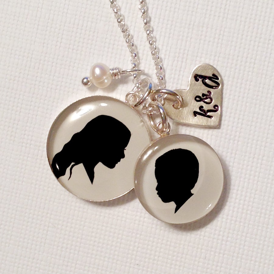 One large and One medium Child or Pet Sterling Silhouette Pendants, stamped heart and pearl