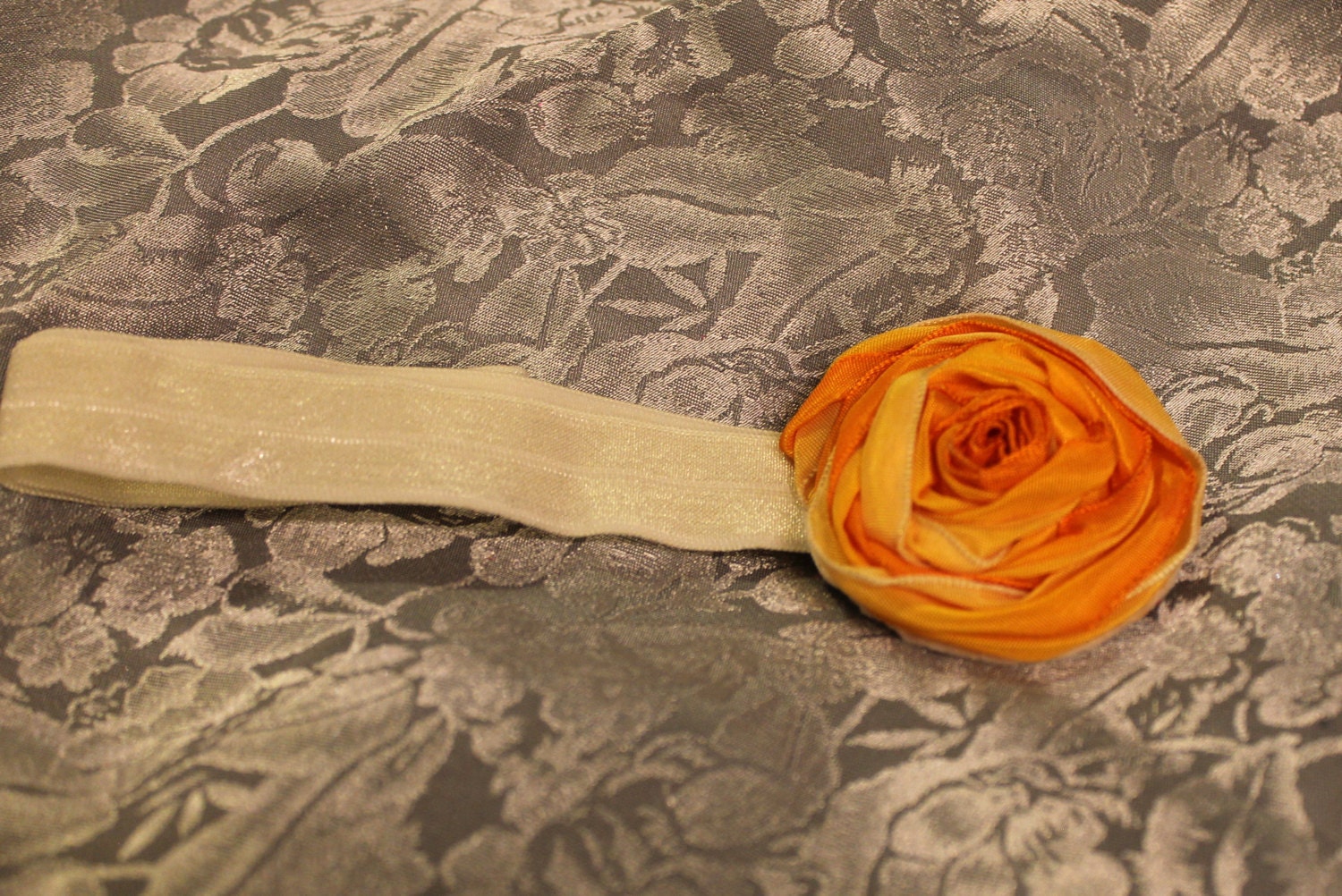 Handmade 1.5"  tangerine ombre rosette on ivory headband stretches to 22" size Medium