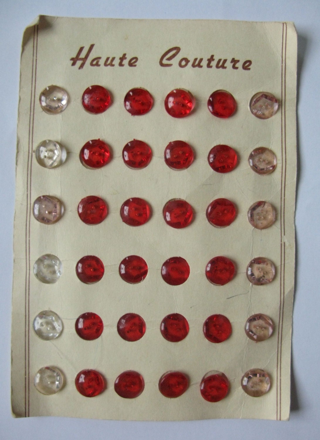 Small red plastic vintage buttons on original card.