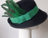 Garbo In Green.  Black fur felt 1940s fedora style tilt hat for women.  Emerald green vintage ribbon with feathers.