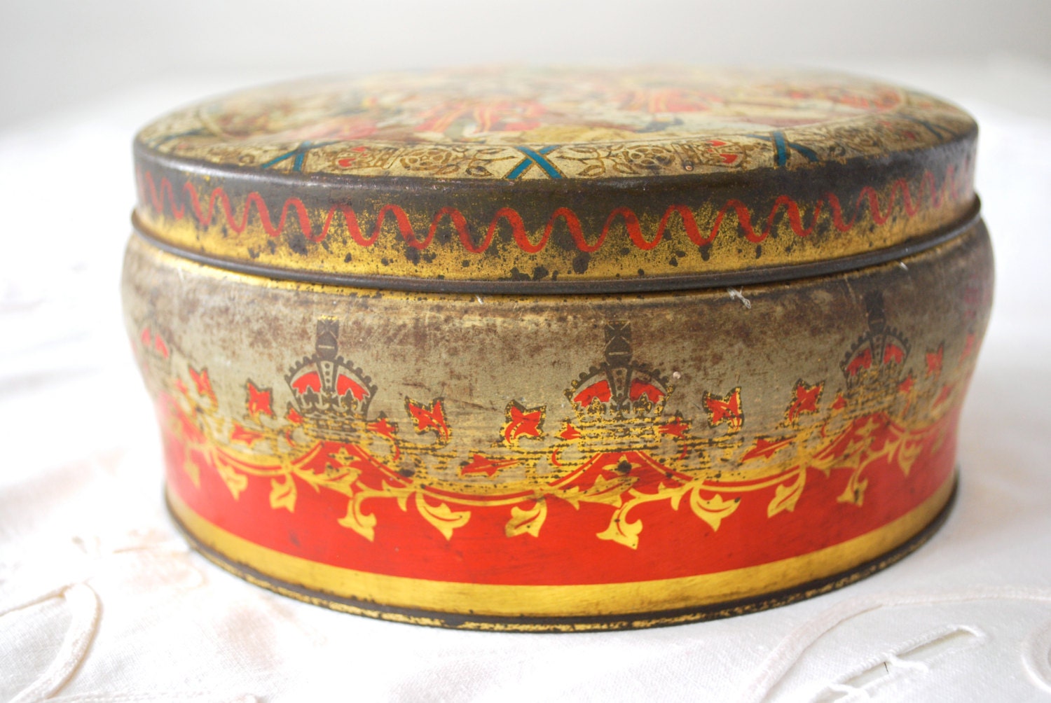 Red and gold vintage tin box with queen parade scene. English Vintage.