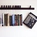 Custom made wooden book rack / bookshelf in Wenge. Pins also work as bookmarks. Bookcase