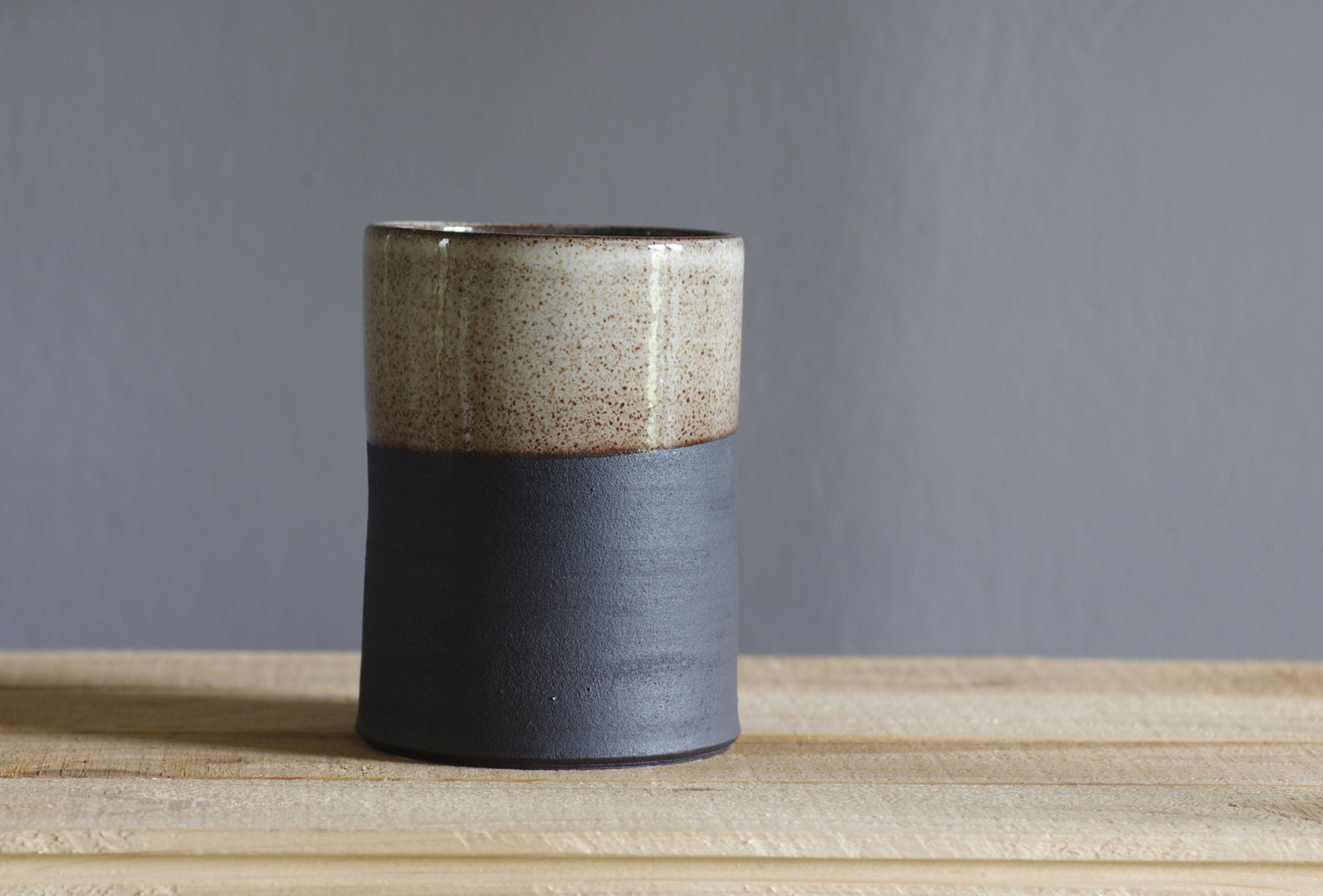 tall straight vase or utensil holder . black stoneware with white glaze. modern minimal pottery ceramic design