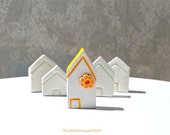 Miniature white clay house with yellow flower, spring home decoration